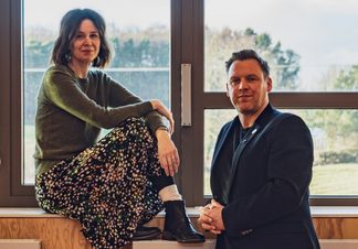 Kate Wasserberg (Artistic Director) and Liam Evans-Ford (Executive Director) posed in front of a window.