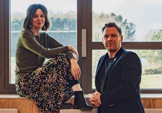 Kate Wasserberg (Artistic Director) and Liam Evans-Ford (Executive Director) posed in front of a window.