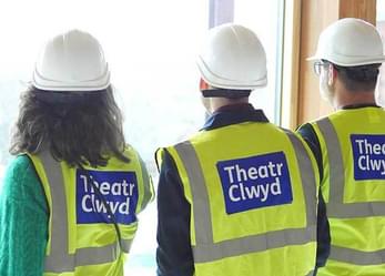 Three people in high vis jackets and helmets with the Theatr Clwyd logo checking out the beautiful views!