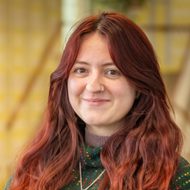 Headshot of Lily Peers-Dent. Red haired white woman.