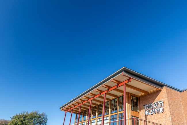 Exterior of Theatr Clwyd building with clear blue sky.