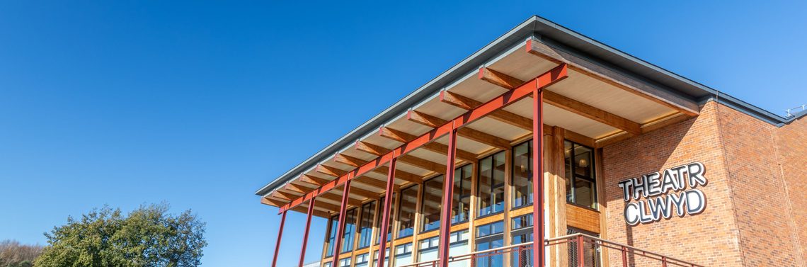 A photo of the front of Theatr Clwyd on a clear blue day.